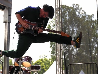 PAL guitarist mid-jump during their performance.