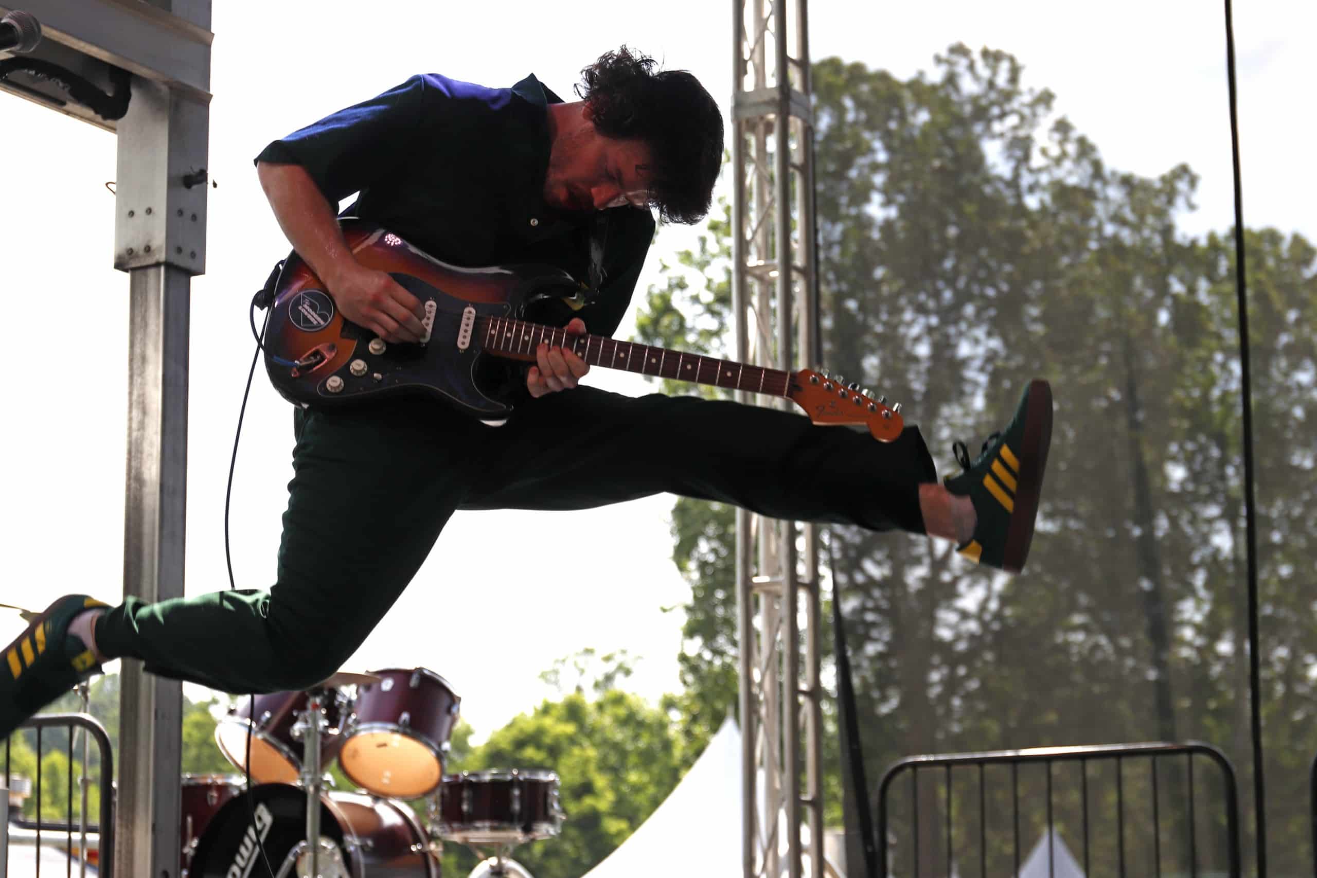 PAL guitarist mid-jump during their performance.