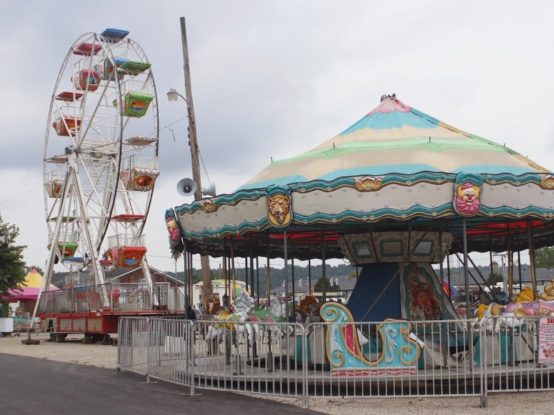 A carousel and a Ferris wheel at the fairgrounds.