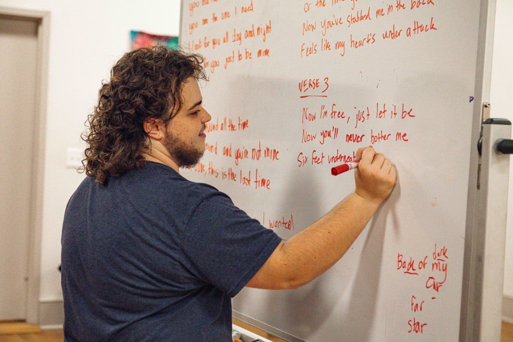 person writing at whiteboard
