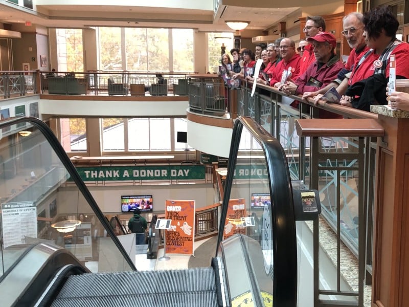 OU Baker Center escalater with UAOU supporters on one side and OU banner reading "thank a donor"