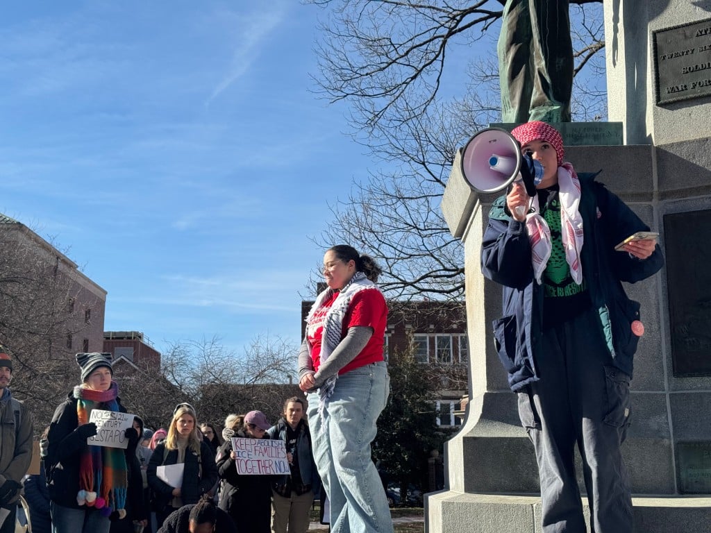 Eden (with megaphone), a member of Students for Justice for Palestine, speaks to demonstrators from the steps of the Soldiers and Sailors monument at College Green on Jan. 23, 2026. At left is Tylar Ayers, vice president of OU’s chapter of the Ohio Student Association.