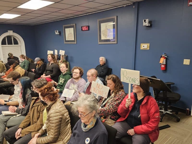 NO DRONES signs at a city council meeting